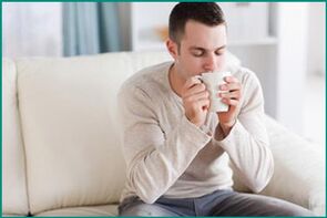 Um homem bebe chá com hortelã, querendo curar a disfunção erétil. 